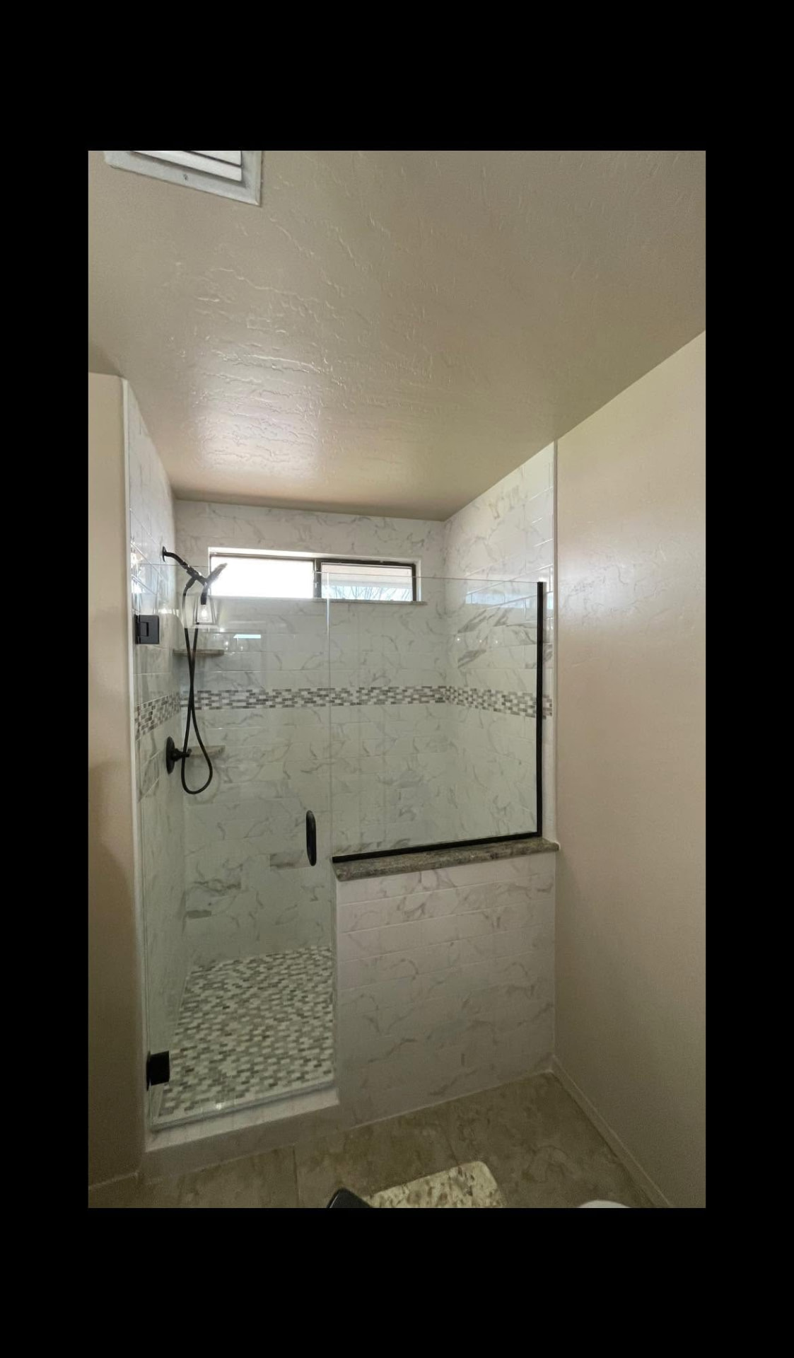 Custom frameless glass shower enclosure with matte black hardware installed by E.A. Glass